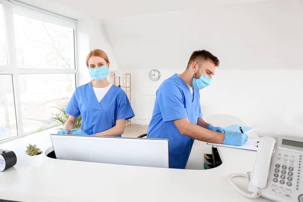 Receptionists working at desk in clinic