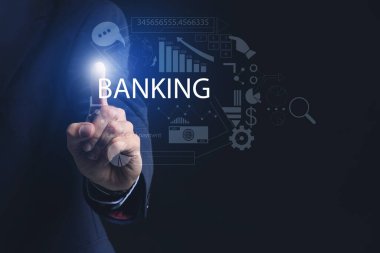 Koyu arkaplanda sanal ekran kullanan bir erkek banka yöneticisi