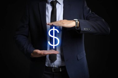 Siyah arka planda dolar işareti olan bir erkek banka müdürü.
