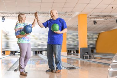Kulüpte bowling oynayan yaşlı çift.