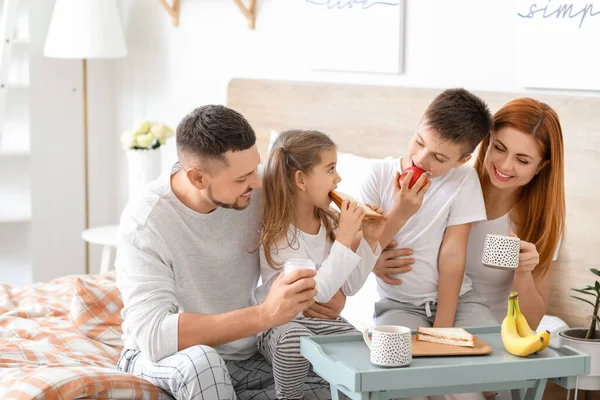 快乐的家庭在家里的卧室里吃早餐 — 图库照片