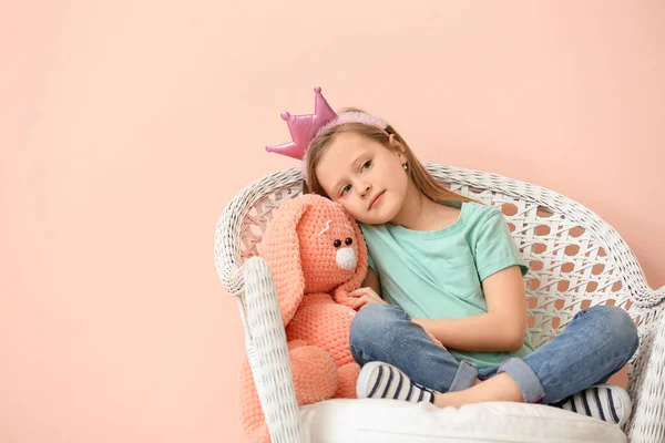 可爱的小女孩 带着玩具坐在靠近彩墙的扶手椅上 — 图库照片