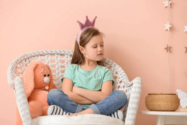 讨厌的小女孩 玩具坐在靠近彩墙的扶手椅上 — 图库照片