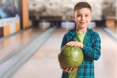 Kulüpte bowling oynayan küçük çocuk.