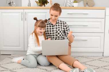 Küçük tatlı kızı ile evde görüntülü sohbet eden bir kadın.