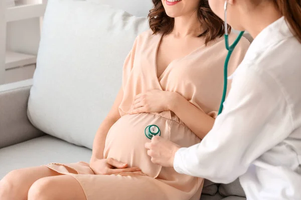自宅で若い妊婦を訪問する医師 — ストック写真