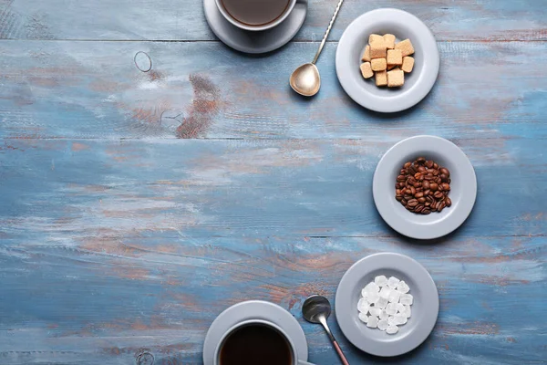 Cups of coffee with sugar on wooden background