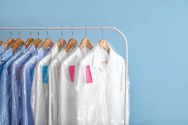 Rak Dengan Pakaian Setelah Dry Cleaning Pada Latar Belakang Warna — Stok Foto