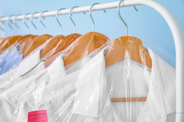 Rak Dengan Pakaian Setelah Dry Cleaning Pada Latar Belakang Warna — Stok Foto