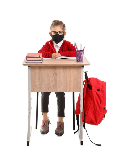 Menina Vestindo Máscara Médica Enquanto Sentado Mesa Escola Contra Fundo — Fotografia de Stock