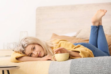 Güzel genç bayan evde çay içiyor.