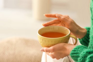 Evde çay içen güzel genç kadın, yakın çekim