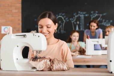 Atölyedeki terzi kursunda genç bir kadın.