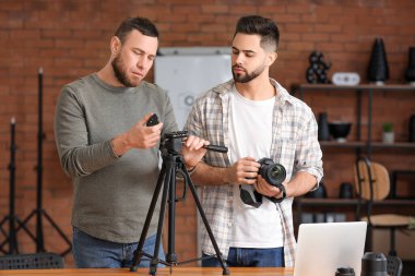 Stüdyoda genç fotoğrafçılara öğretmenlik yapıyor.