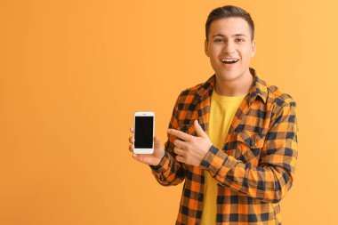 Renkli arka planda cep telefonu olan genç adam