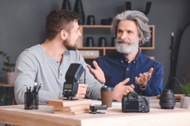 Stüdyoda genç fotoğrafçılara öğretmenlik yapıyor.