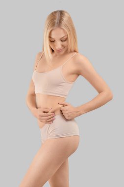 Gri arka planda zayıf bir kadın.