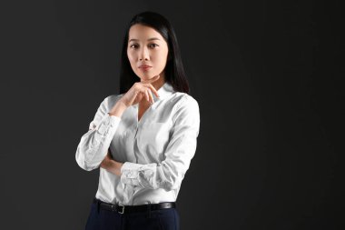 Karanlık arka planda genç Asyalı iş kadını portresi