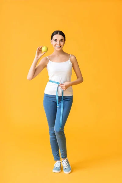 Junge Frau Mit Maßband Und Apfel Auf Farbigem Hintergrund Konzept — Stockfoto