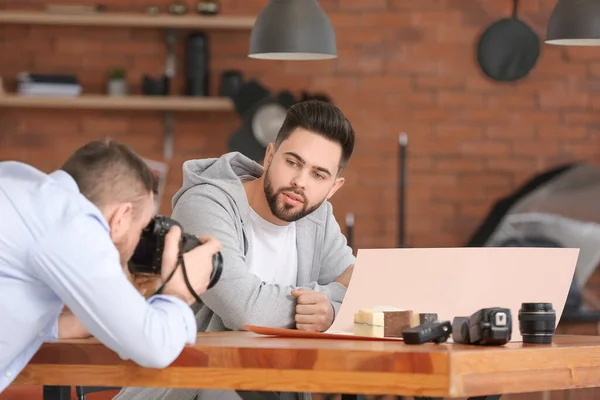 Mentor teaching young photographer in studio