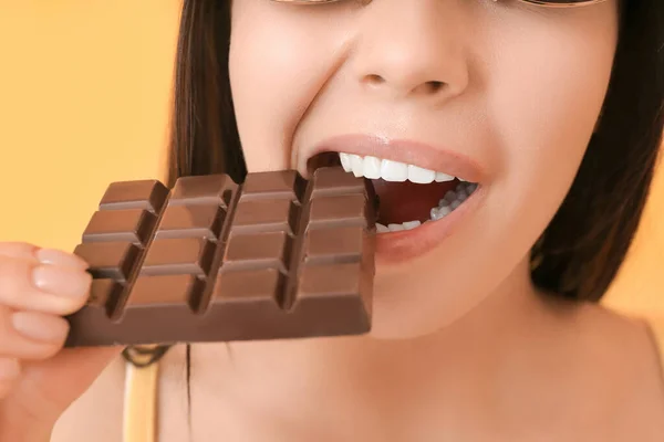 Beautiful Young Woman Eating Tasty Chocolate Color Background Closeup — Stock Photo, Image