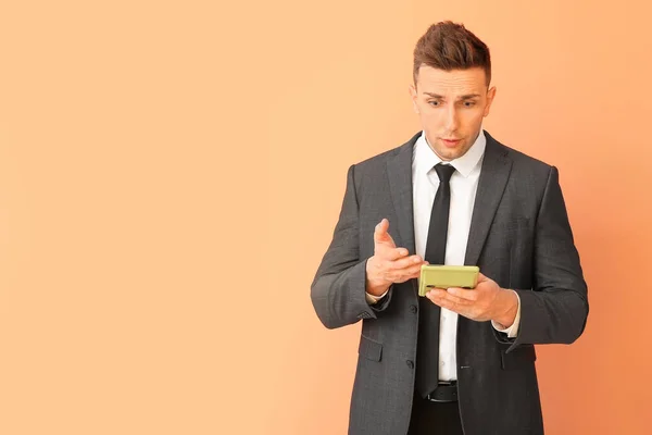 Joven Confundido Con Calculadora Sobre Fondo Color — Foto de Stock