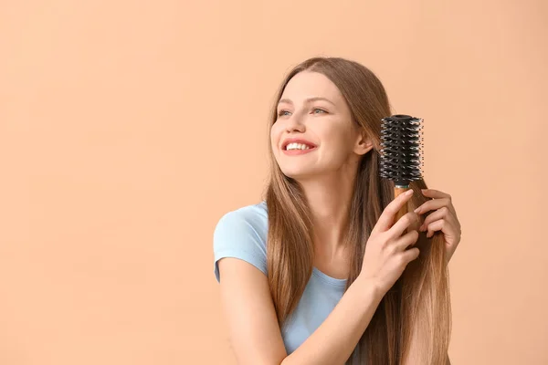 Красивая Молодая Женщина Расчесывает Волосы Цветном Фоне — стоковое фото