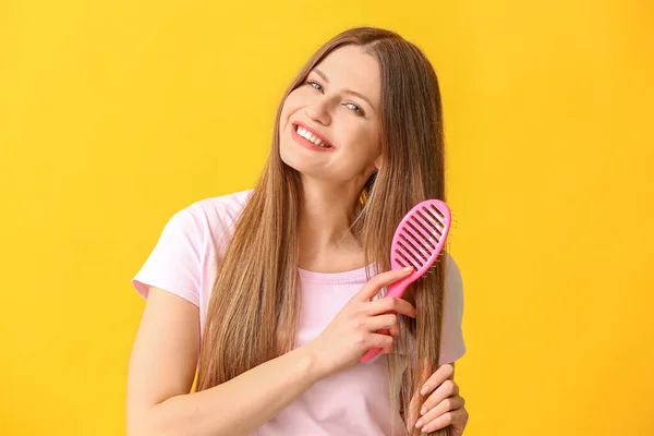 Hermosa Mujer Joven Cepillando Pelo Fondo Color — Foto de Stock