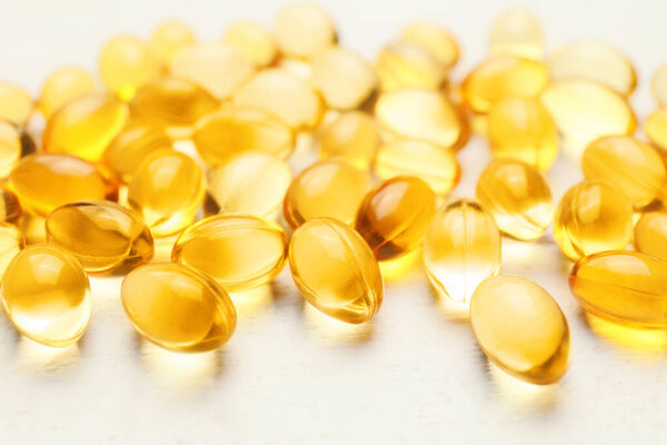 Капсулы с рыбьим маслом на белом столе
