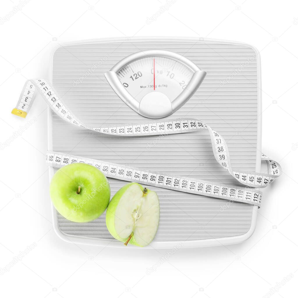 Weight scales with measuring tape and apples on white background. Slimming concept