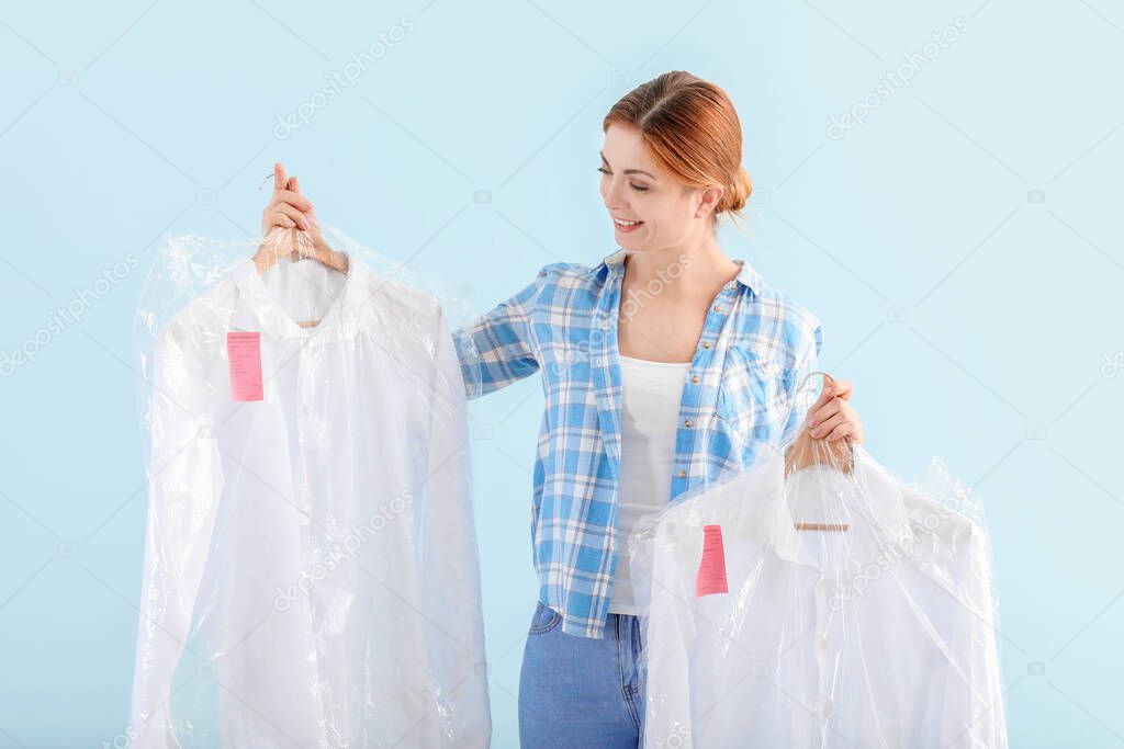 Worker of modern dry-cleaner's on color background