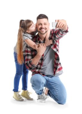 Adam ve küçük kızı beyaz arka planda selfie çekiyorlar.