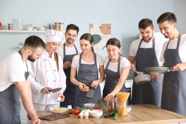 Yemek pişirme dersleri sırasında kadın şef ve bir grup genç
