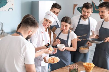 Yemek pişirme dersleri sırasında kadın şef ve bir grup genç