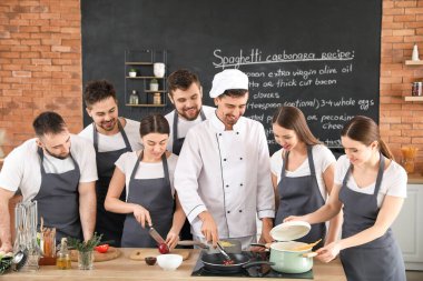 Aşçılık kursunda erkek şef ve bir grup genç.