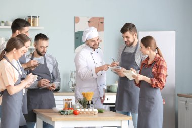 Aşçılık kursunda erkek şef ve bir grup genç.