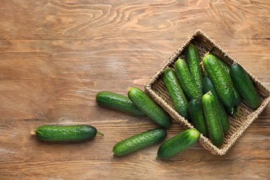 Ahşap arka planda yeşil salatalıklı kutu.