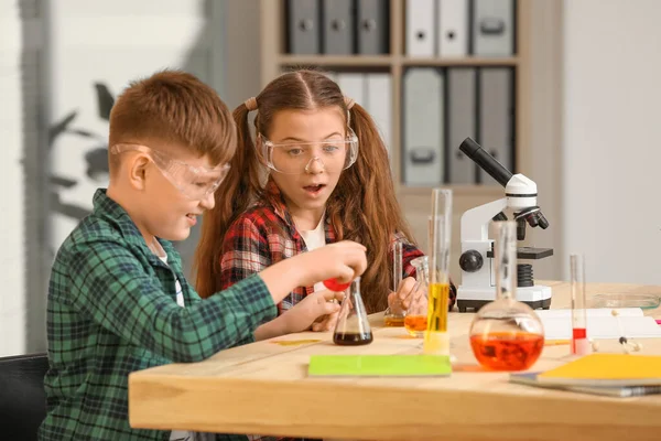 Cute little children at chemistry lesson in classroom