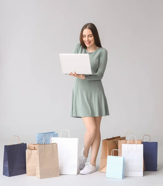 Mujer Joven Con Portátil Bolsas Compras Sobre Fondo Gris — Foto de Stock