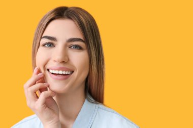 Renkli arka planı sağlıklı dişlere sahip genç kadın