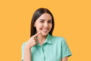 Renkli arka planı sağlıklı dişlere sahip genç kadın