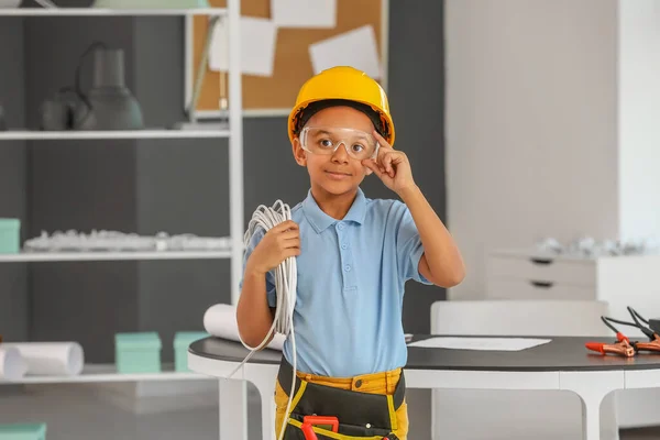 Little African-American electrician in room