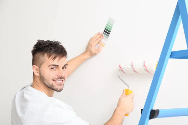 Young Man Choosing Color Wall Indoors — Stock Photo, Image