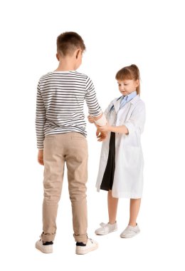 Beyaz arka planda hastası olan sevimli küçük bir doktor.