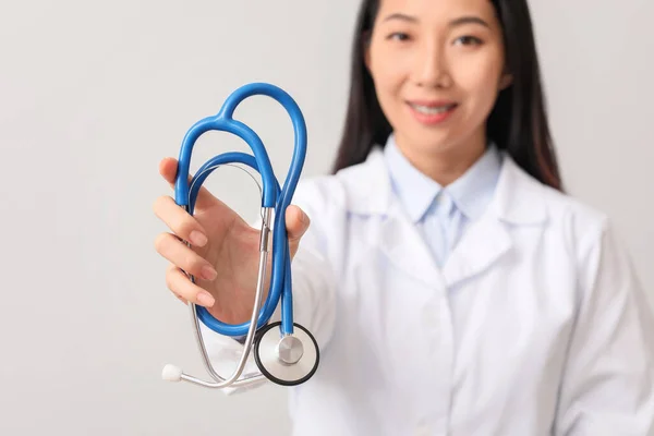 Médica Asiática Com Estetoscópio Fundo Claro — Fotografia de Stock