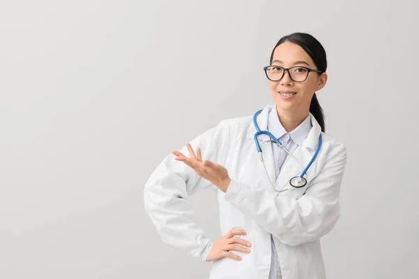 Mujer Asiática Médico Mostrando Algo Luz Fondo —  Fotos de Stock