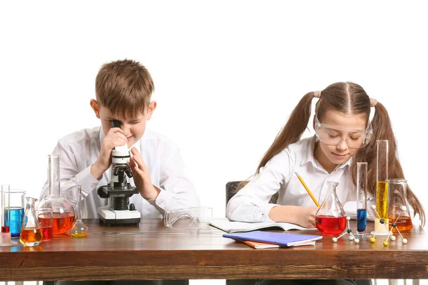 白い背景を背景に化学を勉強するかわいい子供たち — ストック写真