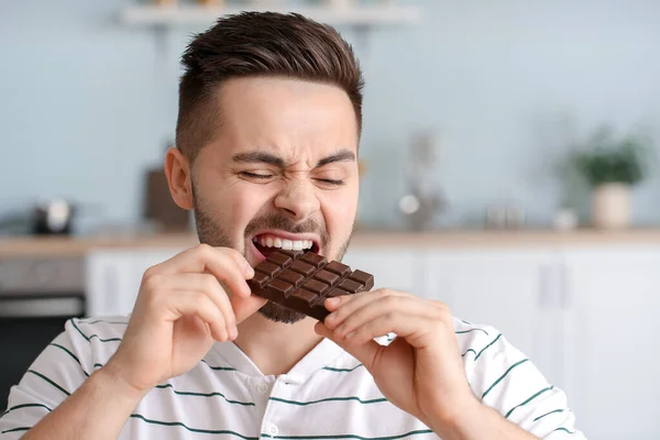 Yakışıklı Genç Adam Mutfakta Çikolata Yiyor — Stok fotoğraf