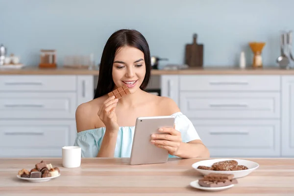 Beautiful Young Woman Tablet Computer Eating Chocolate Kitchen — Stock Photo, Image