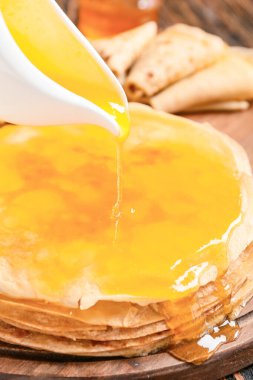 Lezzetli blini 'nin üzerine bal dök masadan, yakından.